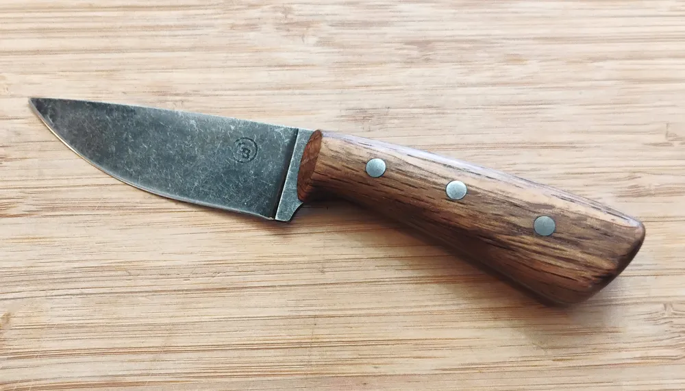 Left view of GreBec 6 1/4" FL Bur Oak Drop Point Caping Knife, 1095 steel blade, Bur Oak handle