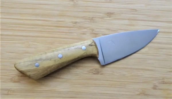 Handcrafted Pignut Hickory 3 Finger Skinner #209 knife with a natural wood handle and 1095 high carbon steel blade, displayed on a bamboo cutting board.