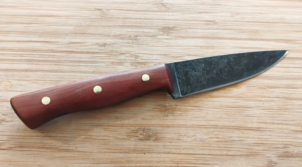 Right view of Red Cedar Bird and Trout #335 Knife, 7 1/4" long, on wood.