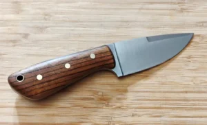 Right side of custom Zebrawood 3 Finger Skinner #303 knife featuring exotic wood handle, brass pins, lanyard tube
