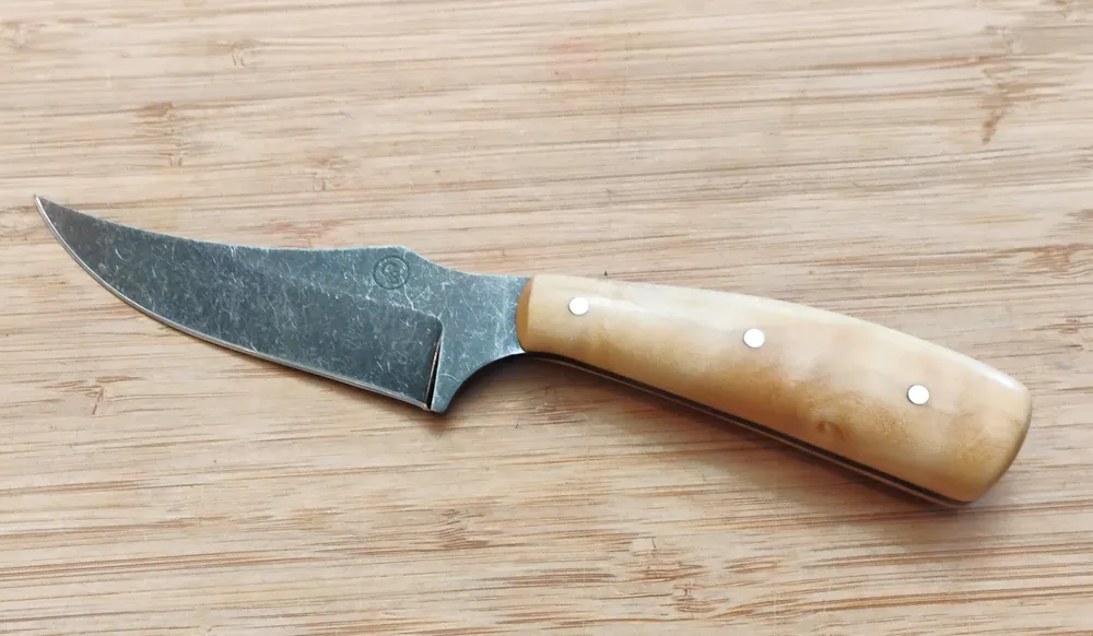 Left Full View of handcrafted Southern Magnolia Trailing Point #331 knife with a light-toned handle and stonewashed blade.