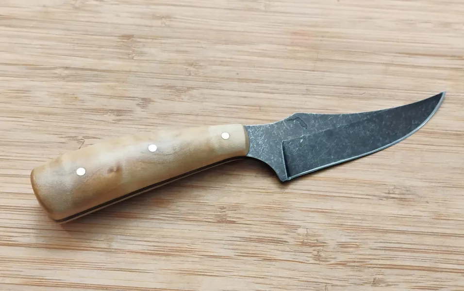 View of the full right side of the custom Southern Magnolia Trailing Point #331 knife with a light-toned wood handle and stonewashed high-carbon steel blade.
