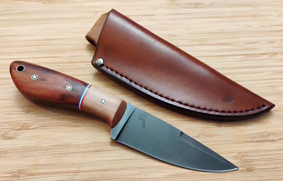 Wild Plum Goldilocks #305 next to custom made leather sheath on a wood background
