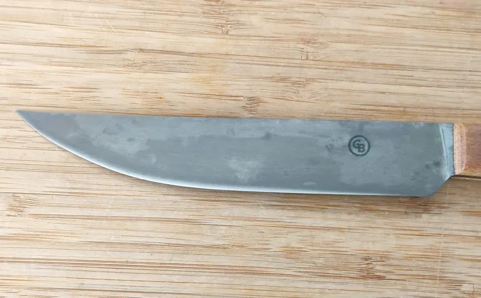 Closeup of the right side of Hard Maple Trade Knife #356 blade, featuring the antiqued 1095 high carbon steel finish and Makers Mark.