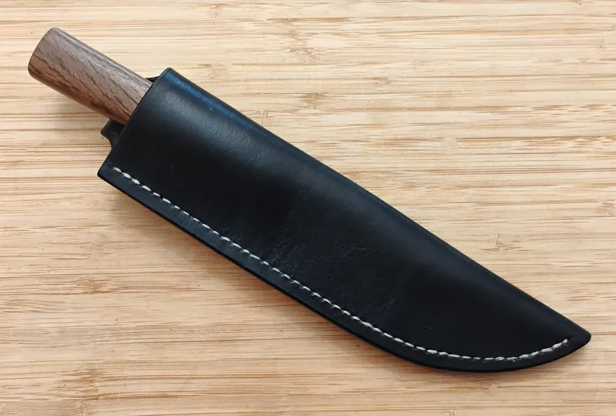 Live Oak French Trade Knife #361 in its black Vinegaroon dyed leather sheath on a wooden surface