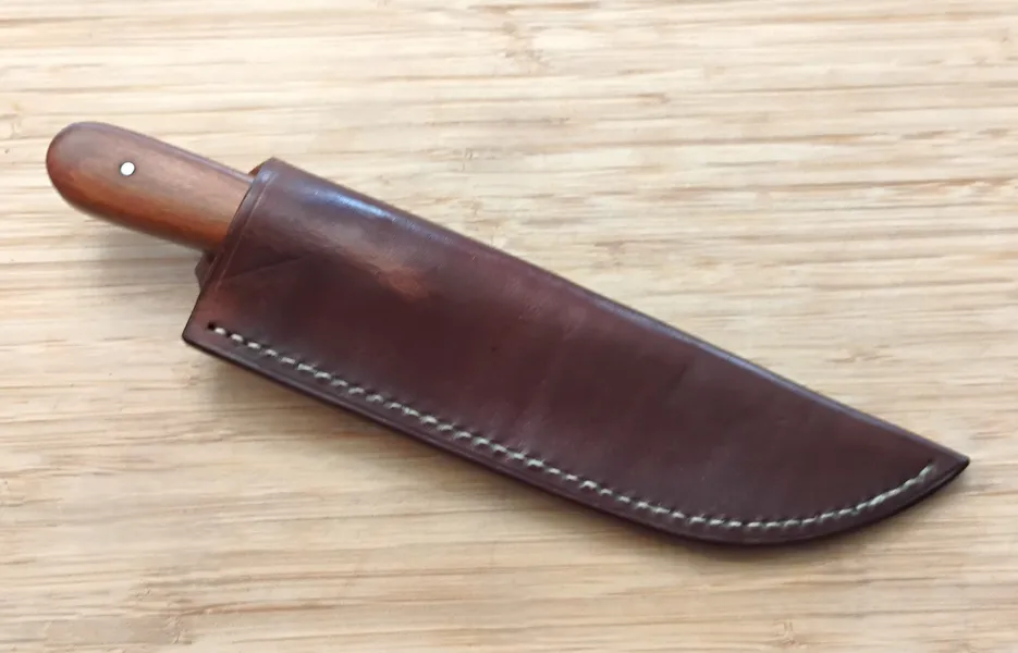 Pernambuco French Trade Knife in its brown Oak Bark leather sheath finished with bees wax on a wooden surface