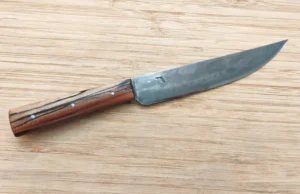 Pecan Trade Knife #365 right side view on wooden surface, showing antiqued 1095 high carbon steel blade with Florida logo.