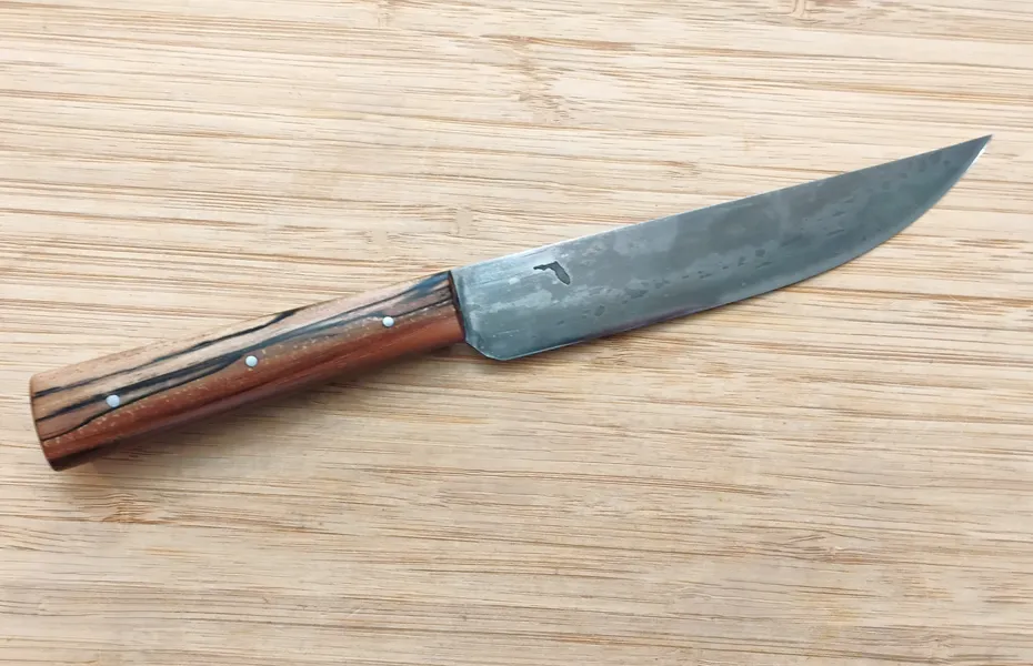 Pecan Trade Knife #365 right side view on wooden surface, showing antiqued 1095 high carbon steel blade with Florida logo.