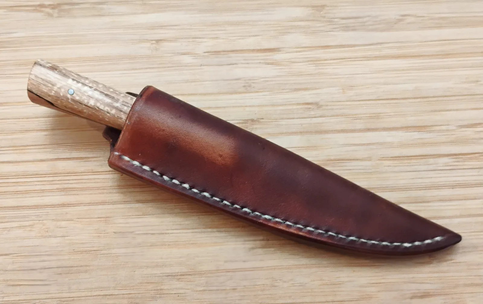 Pecan Tiny Trade Knife in a custom veg-tanned leather sheath dyed with Oak Bark, offering safe storage for kitchen and camping.