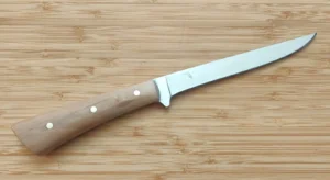 Right side of a GreBec Knives fillet knife showing the etched Florida state outline logo on the polished 1095 high-carbon steel blade, with stabilized Black Olive Wood handle and brass pins.