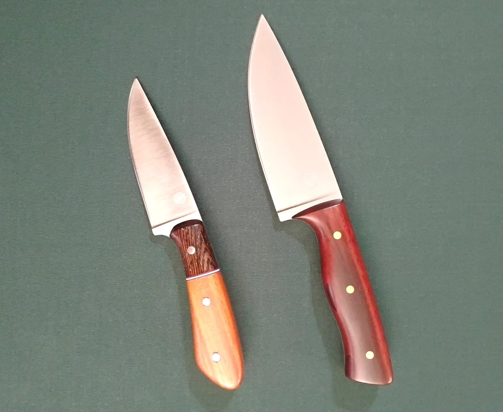 Two custom made knives, one an EDC and one a large camping knife. Both have unique exotic wood handles and brushed blades.