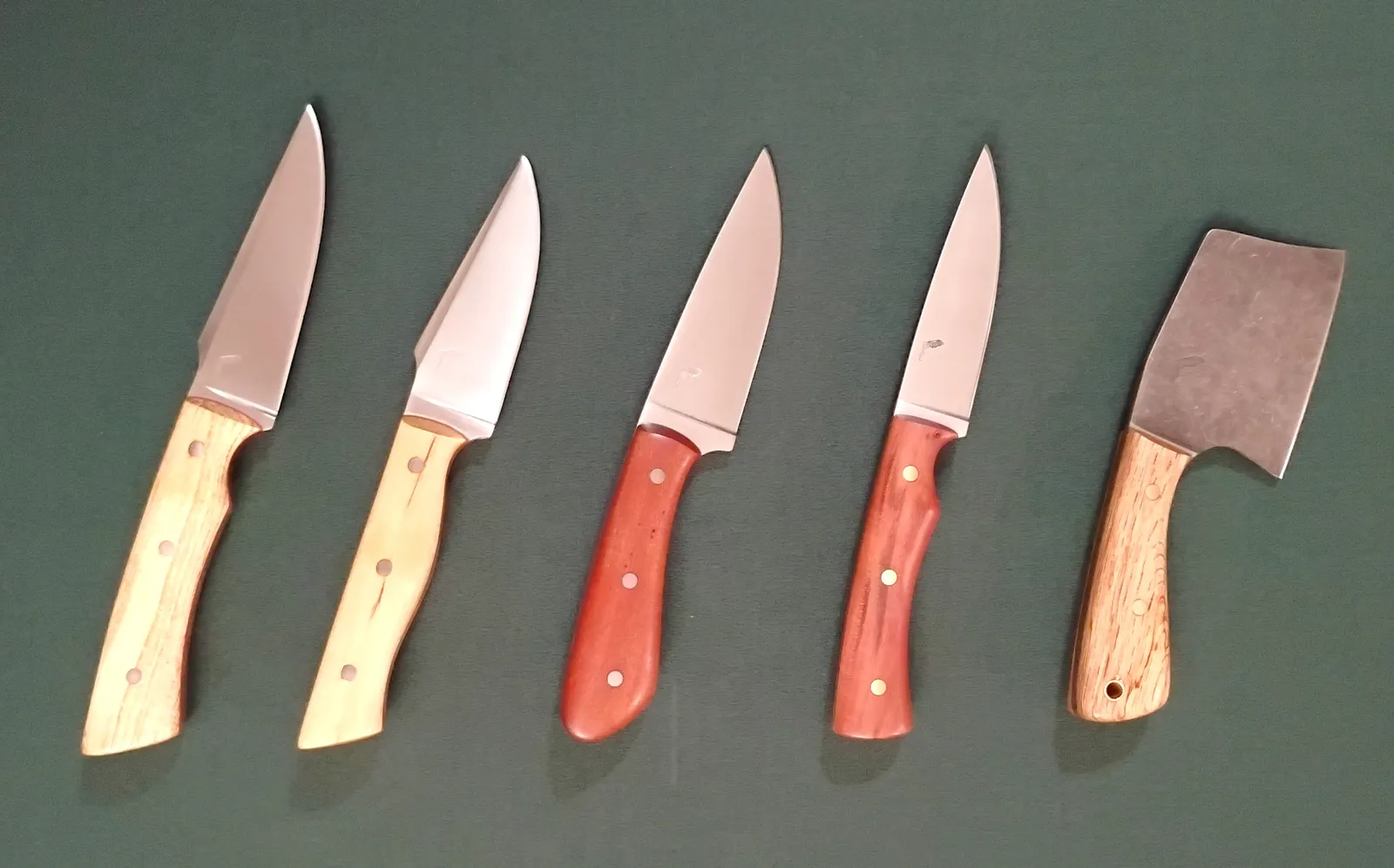 5 Florida Wood Series knifes in a line, starting with a Mini Cleaver followed by four EDC/Hunting knives with different wood handles and blade finishes.