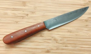 Wild Black Cherry Small French Trade Knife with hand-forged carbon steel blade and Florida Wild Black Cherry handle scales on bamboo background