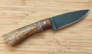 Custom Goldilocks 2 knife with acid-blackened 1095 steel blade, Live Oak bolster, Bur Oak handle, thumb serrations, and mosaic pins.