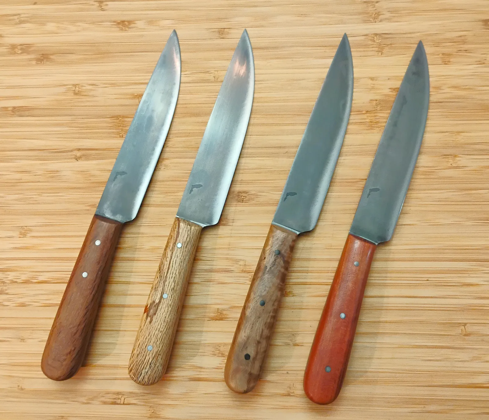 Four French Trade knife recreations with different stabilized Florida wood handles and antiqued blade finishes.