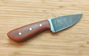 Reverse side of the Red Cedar 3 Finger Skinner #473 showing its contoured handle and three mild steel pins.